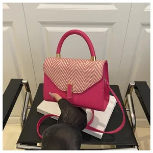 Detail of magenta handbag featuring white herringbone weave and gold hardware accents