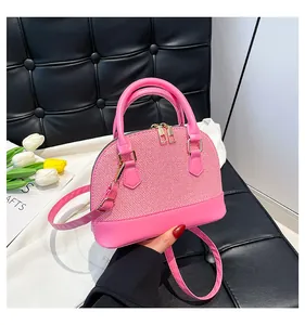 Detailed view of pink shell handbag showing mixed fabric texture and gold hardware details