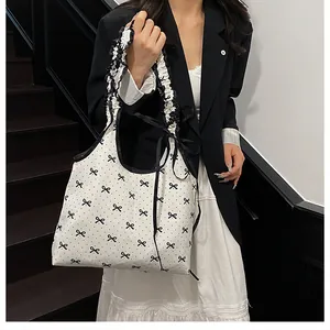 Close-up of pleated ruffled strap with black ribbon on a bow print canvas tote bag