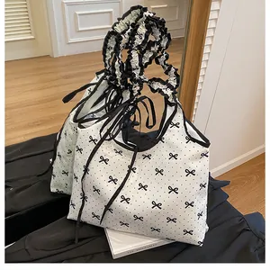 Detailed view of the ruffle handle and bow tie knots on the white canvas tote bag