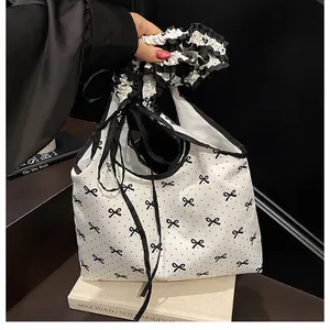 Detailed view of polka dot canvas tote with black ruffle handle and delicate ribbons