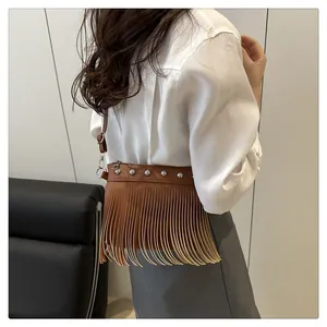 Vista dettagliata della borsa a tracolla bohémien marrone con frange e borchie su modella