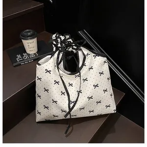 Detail of white canvas tote bag with black bow polka dots and ruffle drawstring closure