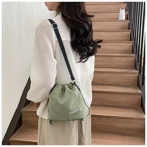 Detail of green drawstring bucket bag with fashion print and adjustable strap