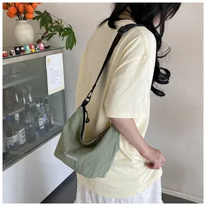 Model wearing a light green fashion hobo bag with adjustable strap and zipper closure
