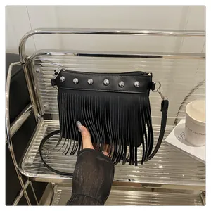 Dettaglio della borsa a tracolla nera con frange, borchie d'argento e zip liscia