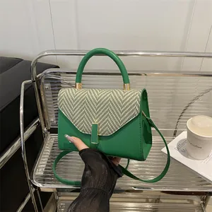 Green leather handbag with black and white herringbone flap and gold metal buckle detail