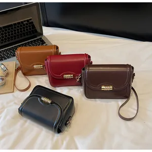 Detail view of four PU leather crossbody bags with gold cylindrical metal twist locks