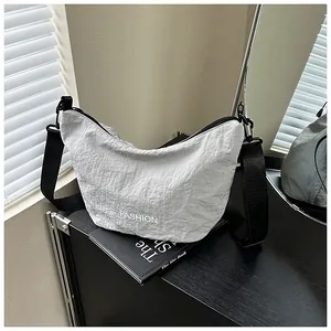 Close-up of the light gray nylon dumpling bag featuring wrinkled texture and FASHION text