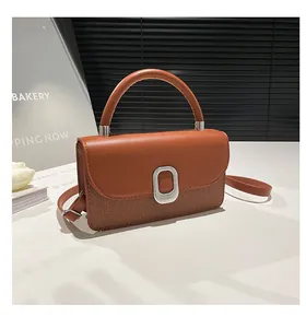 Detail view of brown patchwork handbag featuring smooth leather and woven texture finish