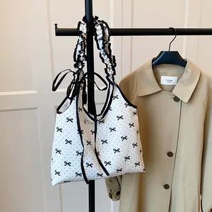 Sweet white canvas shoulder bag with black bow prints and ruffled decorative strap