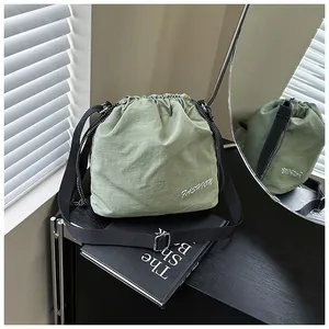 Detail view of green nylon bucket bag with fashion lettering and silver metal buckle