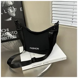 Close-up of black nylon crescent bag with white Fashion text and adjustable strap