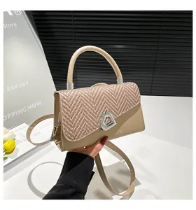 Detail showing beige leather and brown woven texture bag with silver heart buckle
