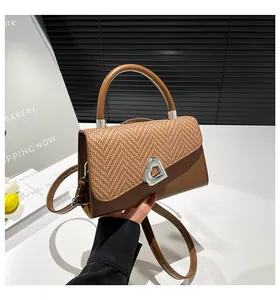 Detail of a brown woven straw handbag featuring a silver heart buckle and round handle