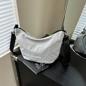 Light gray crescent nylon crossbody bag with wide black strap and fashion print