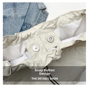 Detail view of magnetic closure on light beige casual crossbody bag with textured fabric