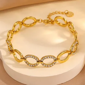 Golden titanium steel bracelet with oval links and sparkling clover rhinestone pavé