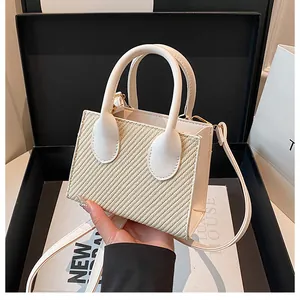 Detail of mini crossbody bag in beige woven texture and white leather in a luxury gift box