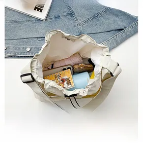 Top view detail of off-white drawstring canvas bag showing large capacity for essentials