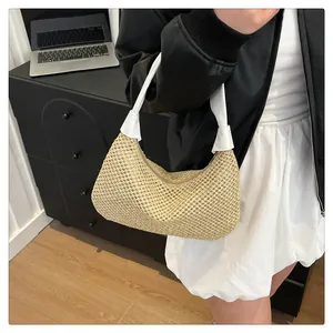 Detailansicht der gewebten Strohtasche mit weißem Lederriemen und Knotendetail