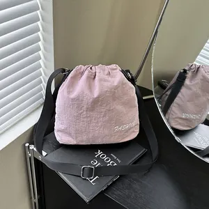 Lightweight lavender nylon drawstring bucket bag with adjustable black shoulder strap
