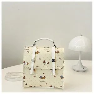 Detail of mini backpack featuring cartoon dachshund prints and cherry bow patterns