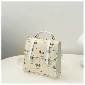 Close-up of a mini cream backpack featuring cute dog patterns and cherry prints