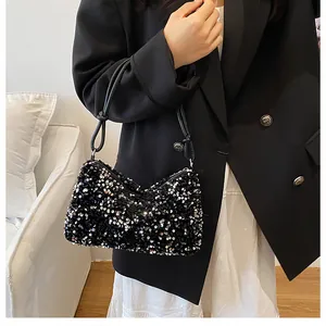 Detail of silver sequin shoulder bag with stylish black knotted strap for evening parties