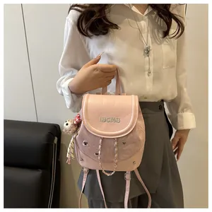 Detail of pink mini backpack with cute animal embroidery, metal chain and plush bear charm