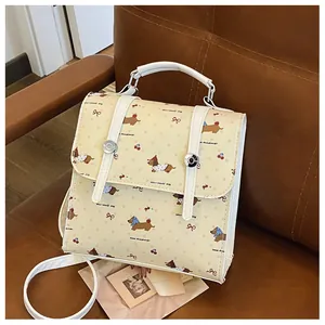 Detailed view of cream mini backpack with dachshund pattern on a vintage leather chair