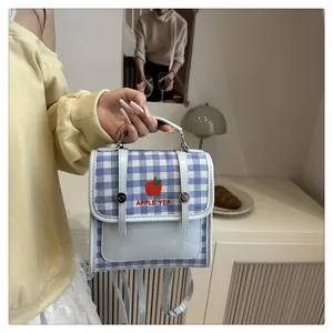 Dettaglio mini zaino a quadretti blu con ricamo a mela e finiture in ecopelle