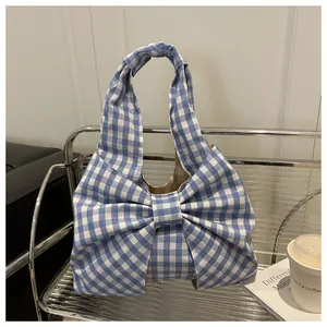 Dettaglio della borsa tote a quadretti vichy blu con un grande fiocco decorativo