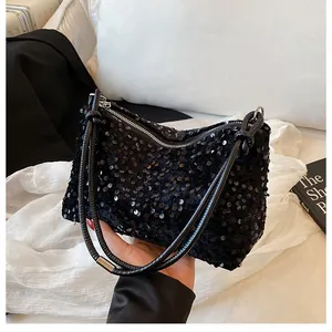 Detail of black sequin shoulder bag showing shimmering circular texture and silver zipper