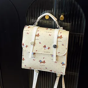 Mini cream backpack with dachshund and cherry print, featuring white straps and handles