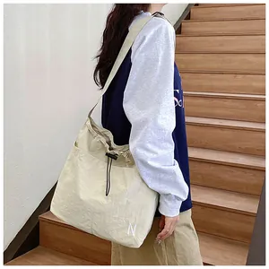 Detail of drawstring closure and N embroidery on a large off-white casual tote bag