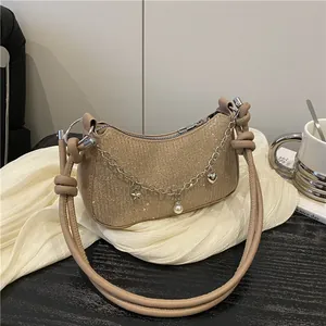 Sac bandoulière pailleté champagne avec chaîne d'étoiles sur fond en soie élégant