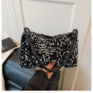 Close-up of black sequin shoulder bag with sparkling texture and silver zipper detail