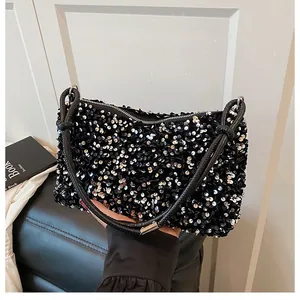 Close-up of black sequin shoulder bag with shimmering texture and zipper detail
