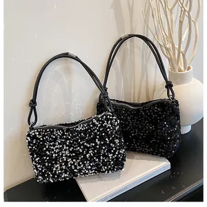 Detail of sequined shoulder bags in black and silver with stylish knotted handles