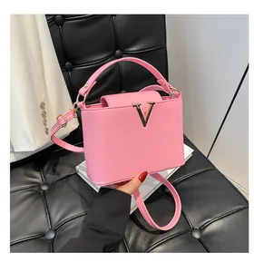 Détail du sac à main en cuir rose avec boucle en métal doré sur un siège texturé