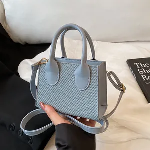 Light blue mini crossbody bag in textured fabric and smooth leather finish