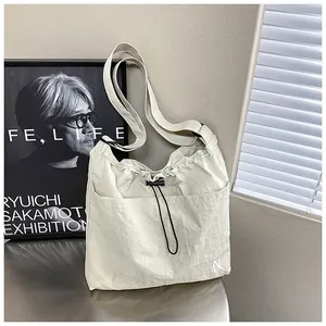 Detail of off-white nylon crossbody bag with drawstring closure and side pockets