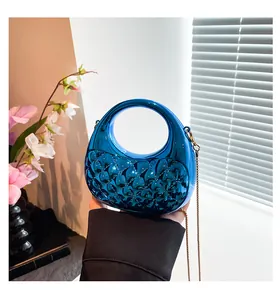 Detail of blue metallic handbag with diamond quilting and detachable gold chain strap