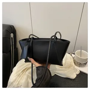 Vue détaillée d'un sac sous les aisselles en cuir PU noir mat avec un pendentif décoratif