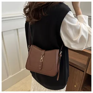 Detailed back view of a vintage brown leather underarm bag with gold infinity buckle