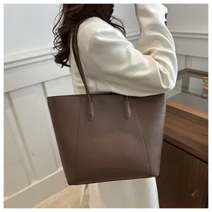 Detail of the high-quality lychee grain texture and logo on the large brown tote bag