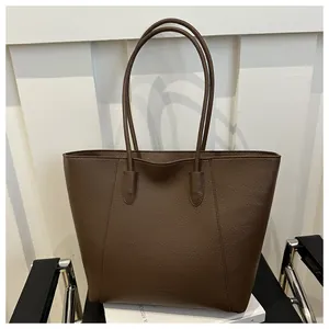 Detailed texture of dark brown pebbled leather tote bag with embossed fashion lettering