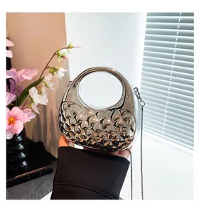 Detail of silver metallic rhombic quilted handbag with elegant integrated handle and chain