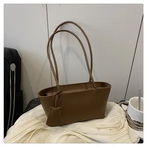 Gros plan du sac cabas en cuir mat marron foncé sur soie avec une tasse de café